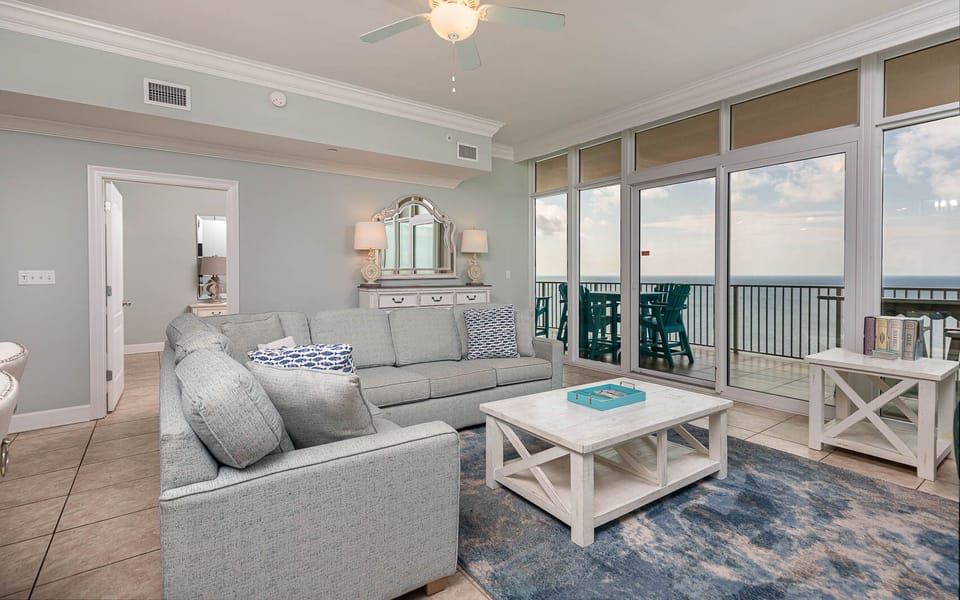 Relax in this inviting living area, featuring a sofa with queen sleeper, coastal decor, and beachfront balcony access