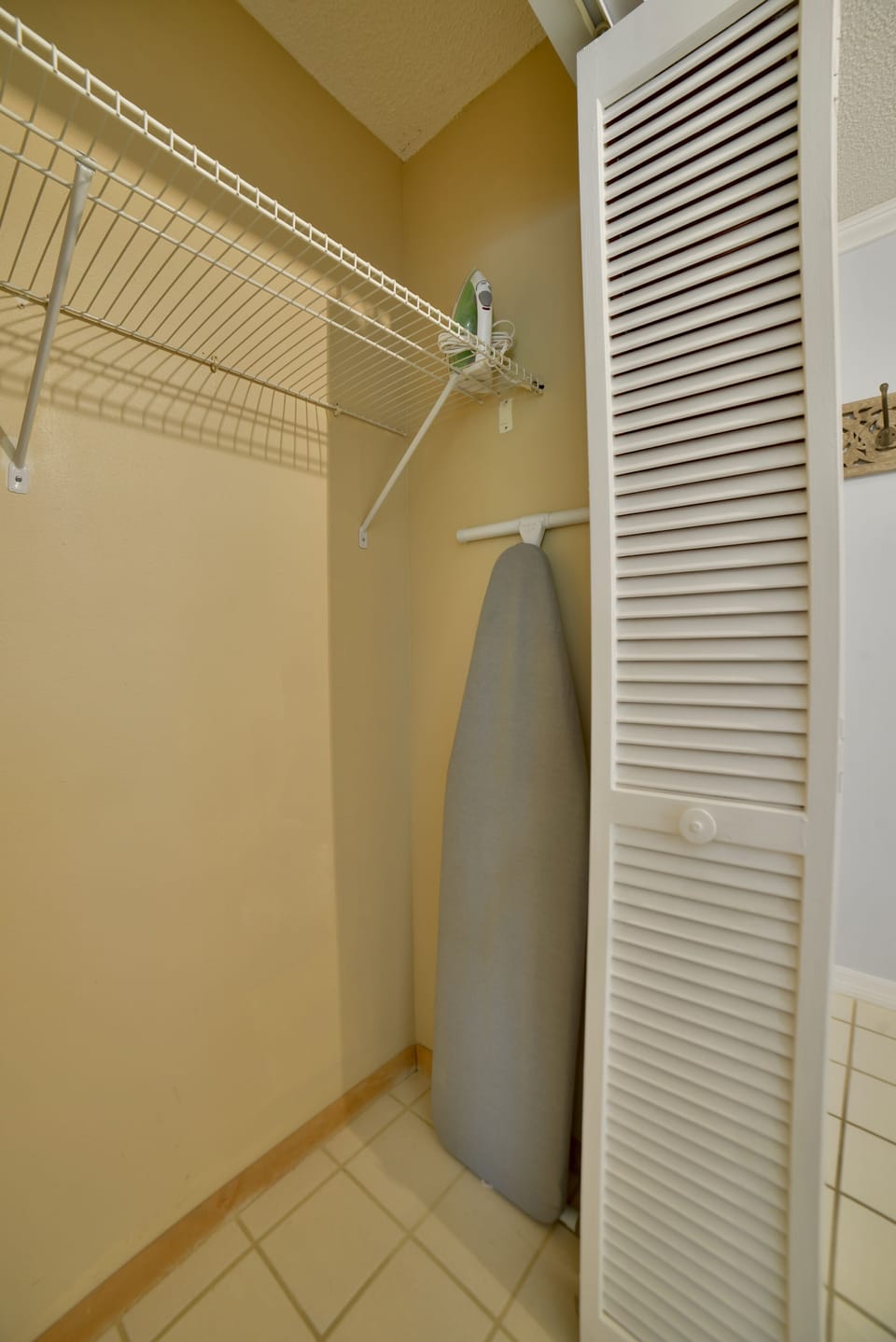 Entry closet with ironing supplies.