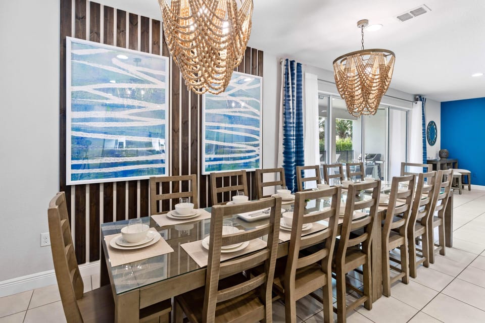 - Large dining room with two long family tables  
- Modern lighting and wall art for stylish setting  
- Perfect space for shared meals and celebrations
