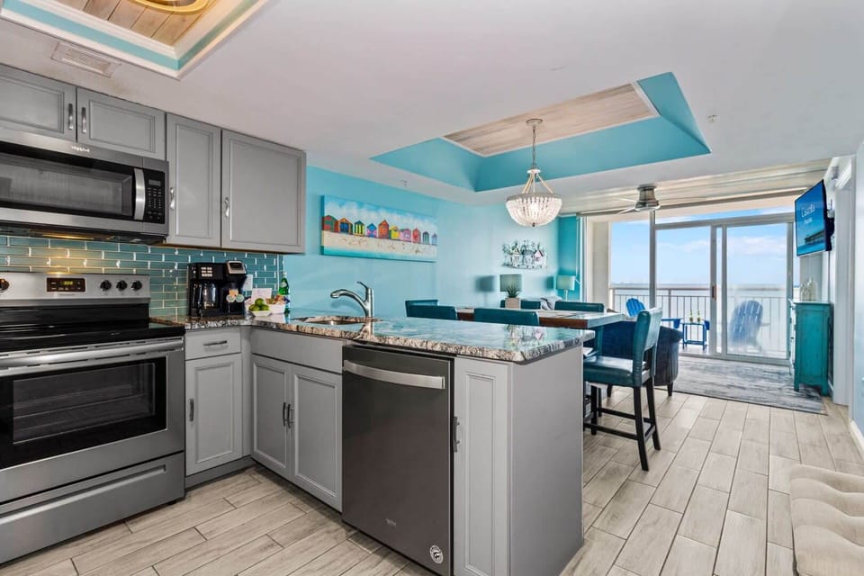 Cook, dine, and relax in this stunning open-concept space featuring a modern kitchen with granite countertops, stainless steel appliances, and vibrant coastal accents. The dining area flows seamlessly to the living room, all with gorgeous ocean views