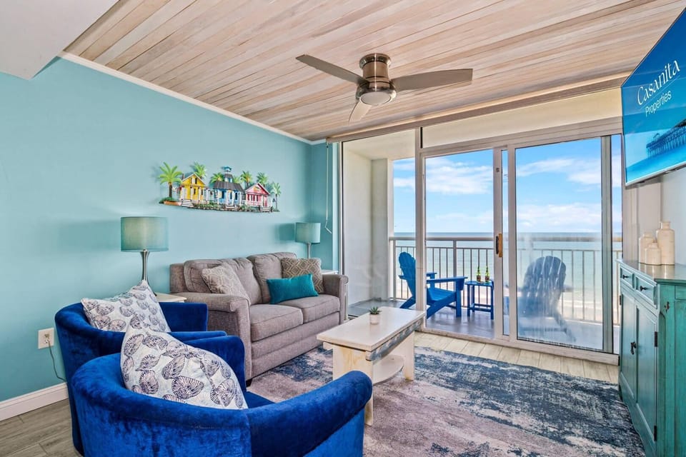 Step into this inviting living space with vibrant coastal decor, plush seating, and a private balcony showcasing breathtaking ocean views. Perfect for relaxing after a day at the beach, this room brings comfort and style to your seaside retreat.