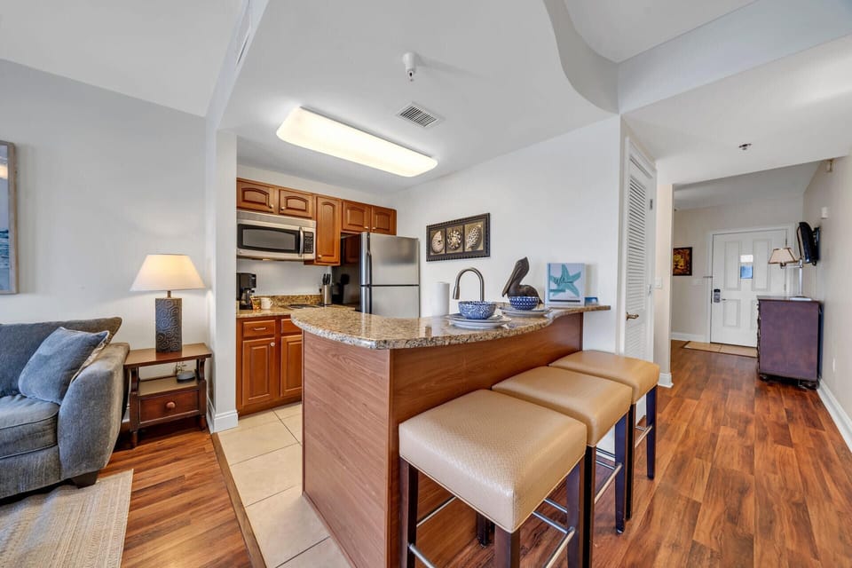 Your stylish open-concept living space features a fully-equipped kitchen with granite countertops, perfect for preparing meals and entertaining guests.