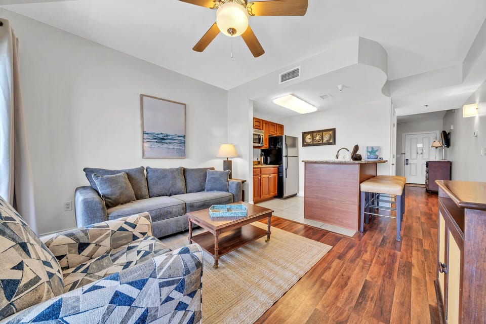 Your spacious living area flows seamlessly into the kitchen, featuring comfortable seating and coastal charm perfect for relaxing.
