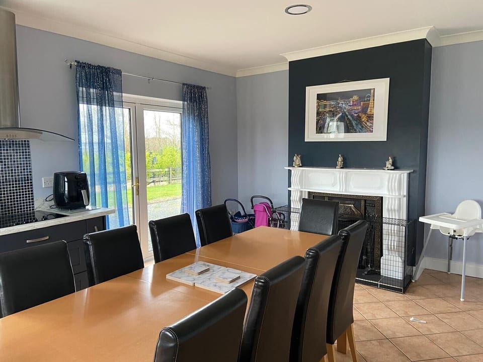 Ballygarrett Holiday Home, County Wexford. Large dining table seats 6 with open fire.