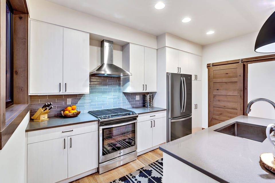 View of the kitchen; laundry area is located behind the wooden sliding door