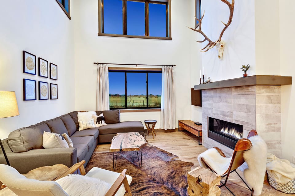 Enjoy the stone fireplace and mountain views in the living room