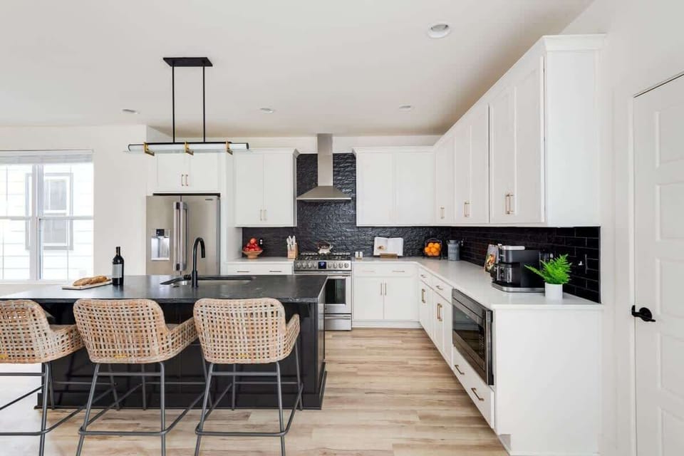 Clean and Spacious Kitchen with Sleek Countertops and Additional Seating