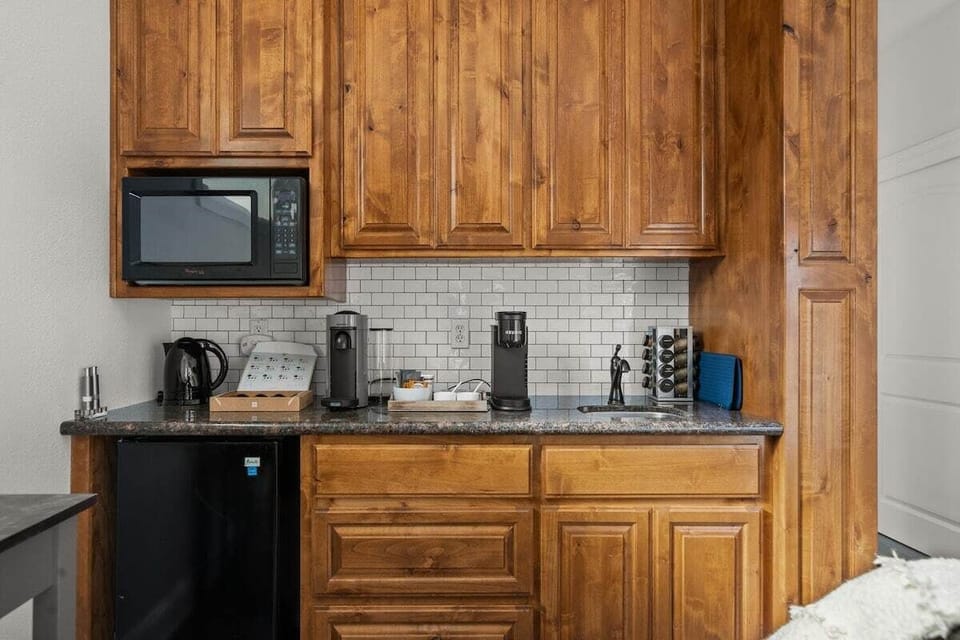 Kitchenette complete with bar sink, microwave, mini fridge, and coffee/tea bar
